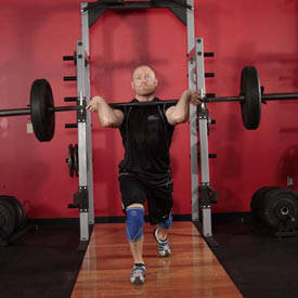 Split Clean step three, man performing second lift pull resting weight on shoulders and splitting feet  https://get-strong.fit/Fitness
